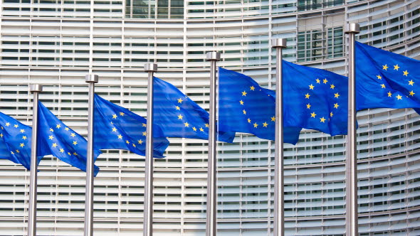 En rad EU-flaggor framför EU-kommissionens  huvudkontor i Bryssel.