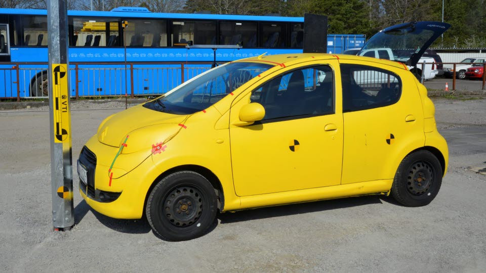 Car standing in front of a post.