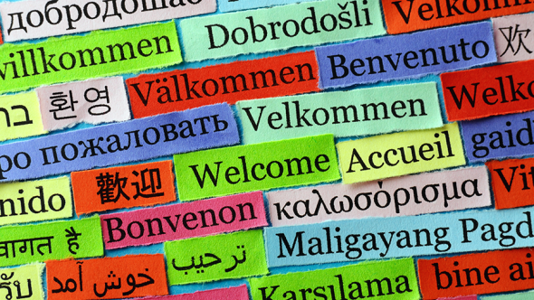 Ordet välkommen på en massa olika språk och olikfärgade lappar.