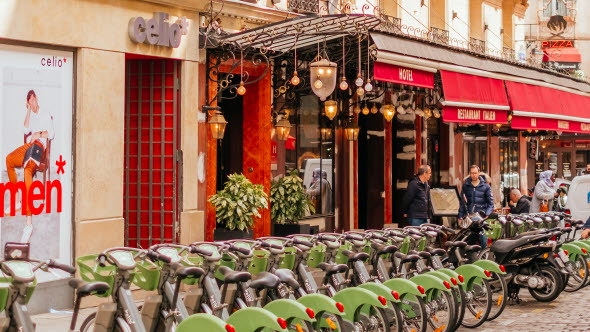 En rad med hyrcyklar uppställda utanför ett hotell i Paris.