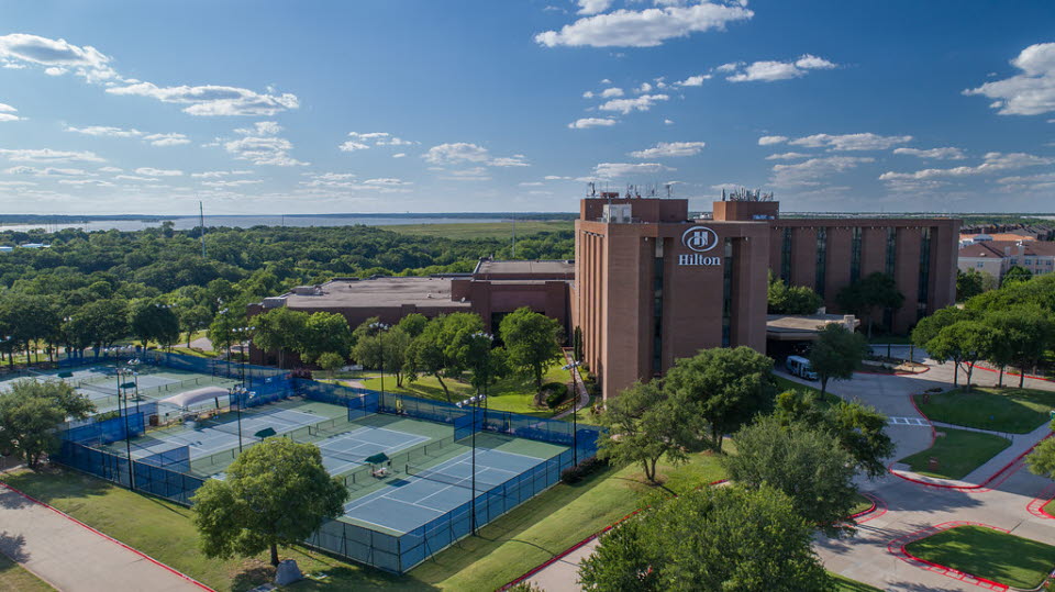 View of Hilton Hotel with tennis courts beside the building. 