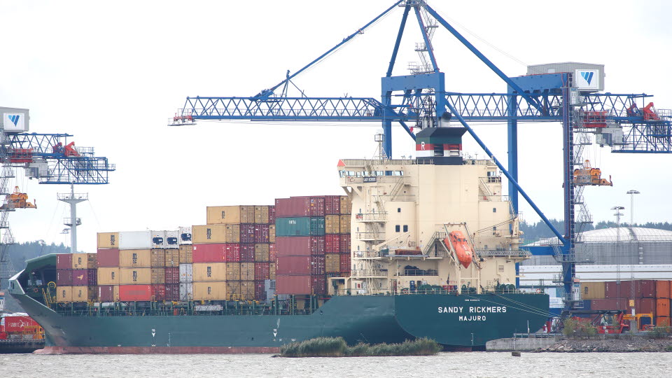 Staplade containrar lastade på ett fartyg.