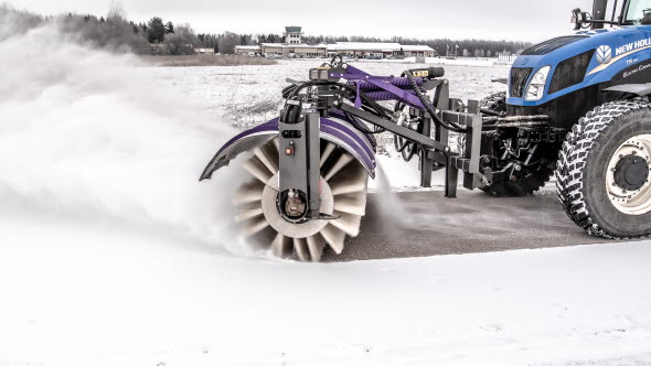 Sopvals på traktor borstar bort snö från cykelväg.