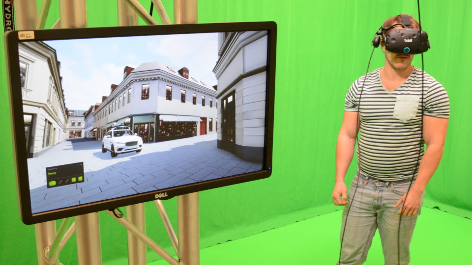 Kille med VR-hjälm och en bildskärm som visar simulering.