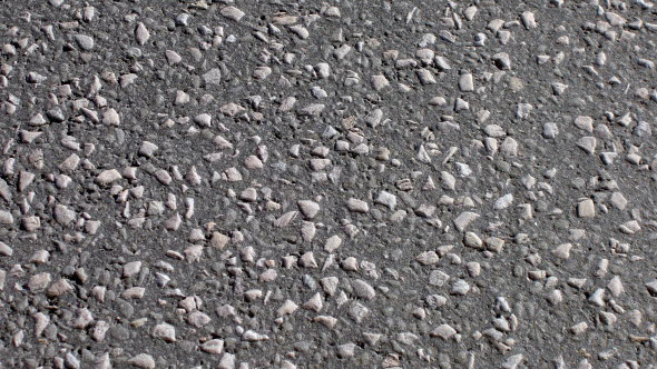 Närbild på en väg där man ser texturen i asfalten.