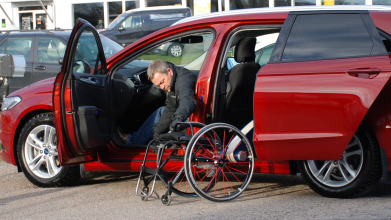 Förare i bil anpassad för funktionshinder.